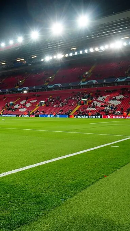 Football stadium and green pitch under bright floodlights