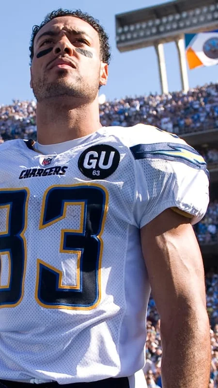 A Chargers player standing on the field in a football stadium