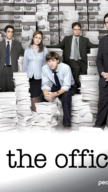 The Office cast standing among stacks of Dunder Mifflin paper boxes